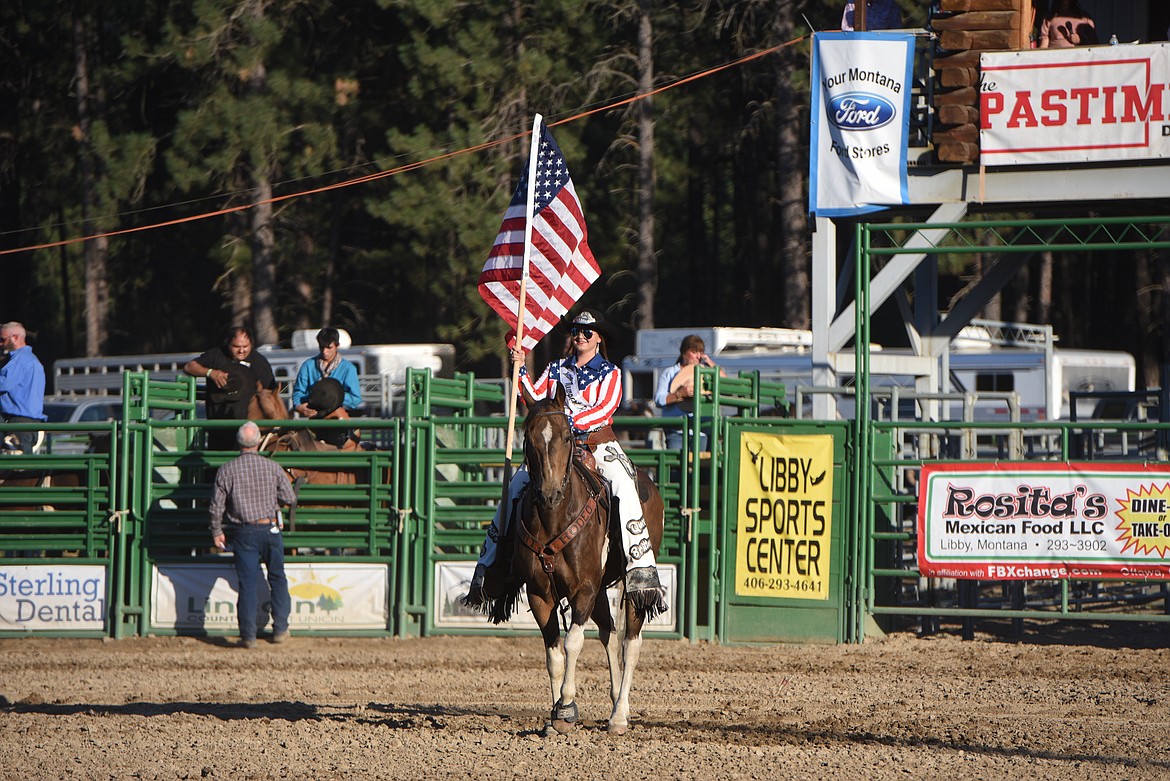 Brittney Jackson, the 2022 Newport, Washington Rodeo Queen, proudly displays the U.S. flag Saturday night at the Kootenai River Stampede. (Scott Shindledecker/The Western News)