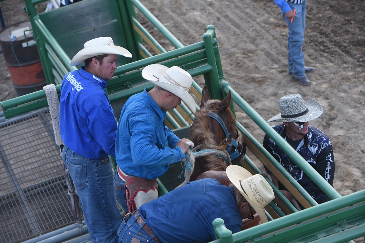 Libby's Jason Colclough, center, prepares for his saddle bronc ride on Ryan's Hope Saturday night at the Kootenai River Stampede. (Scott Shindledecker/The Western News)