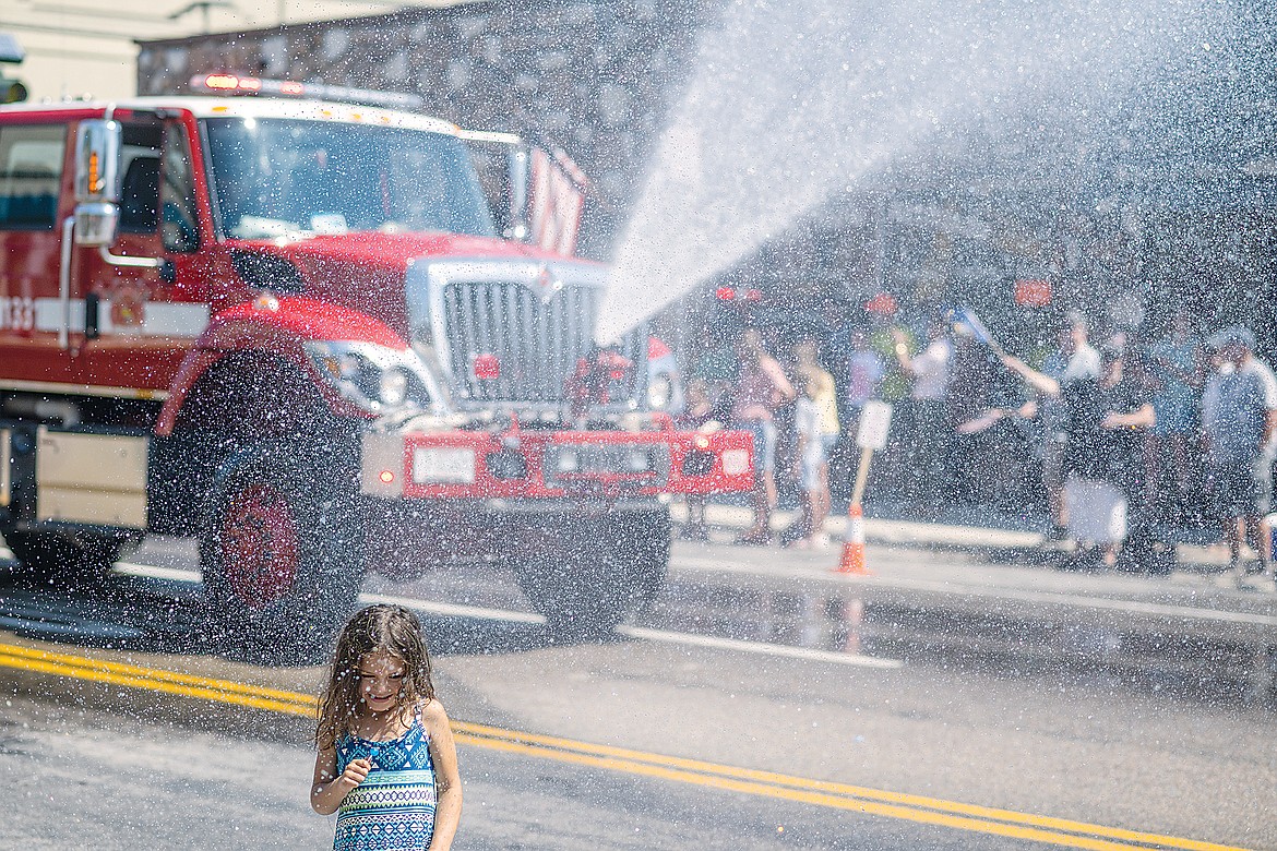 A youngster cools off with help from a fire truck.