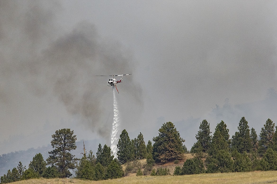 A helicopter drop water on the Elmo Fire burning west of Flathead Lake near Elmo on Saturday, July 30, 2022. (Rob Zolman/Lake County Leader)