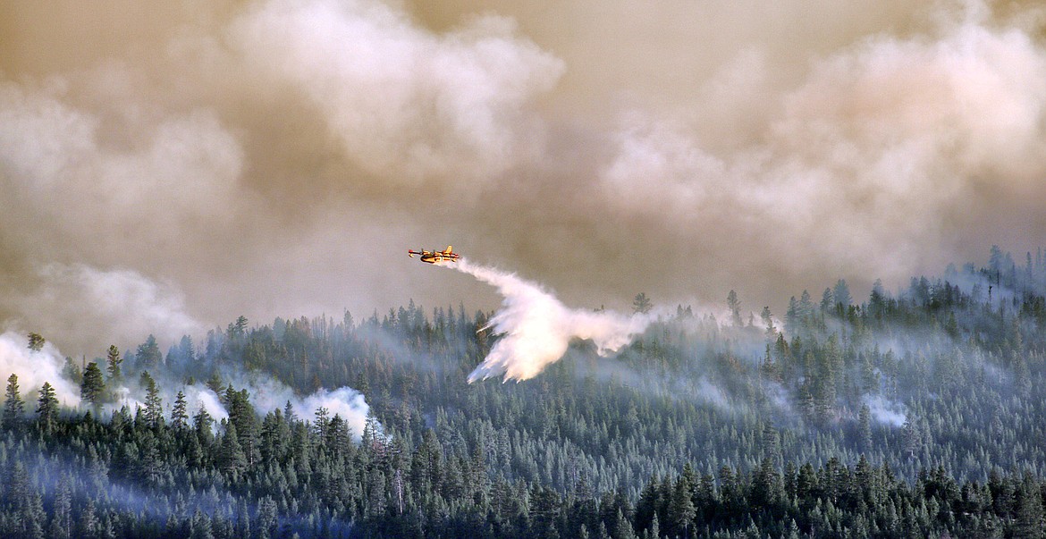 Scooper planes douse the flames of the Elmo 2 Fire west of Flathead Lake on Sunday evening. (Patrick Booth/Mystic Creek Studios)