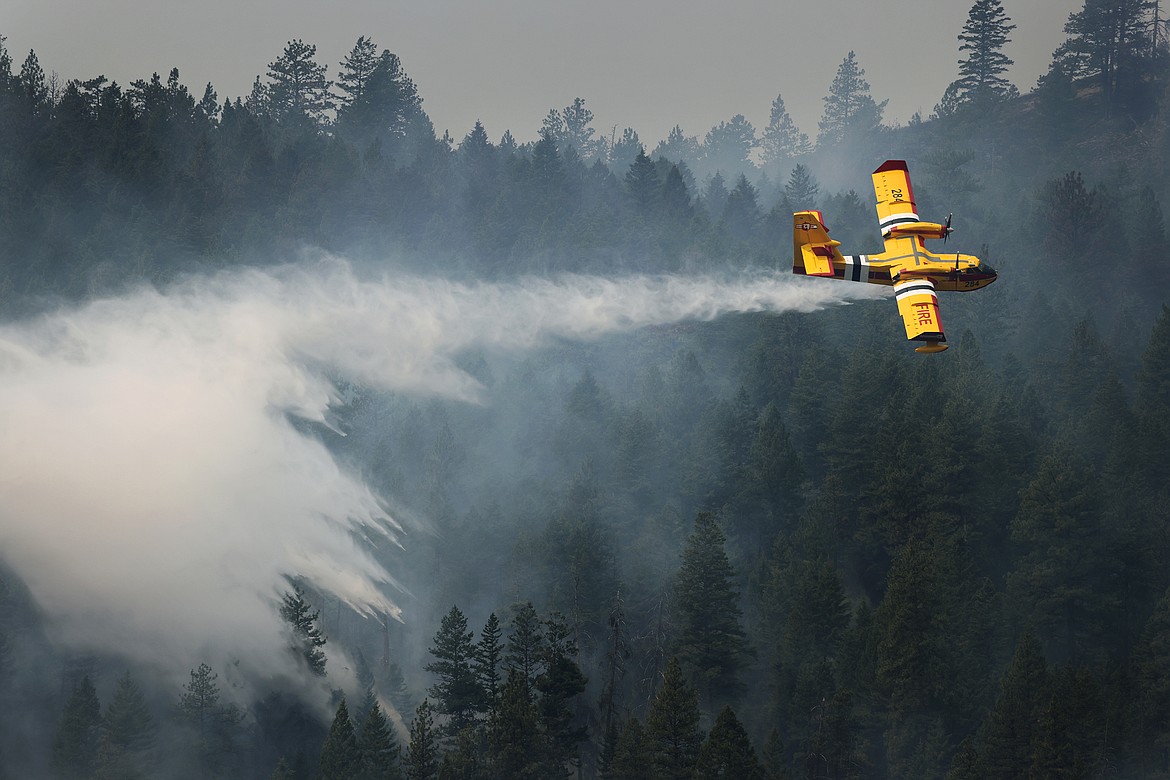 A CL-415EAF super scooper dumps water on the leading edge of the Elmo Fire near Black Lake Monday, August 1. (Jeremy Weber/Daily Inter Lake)