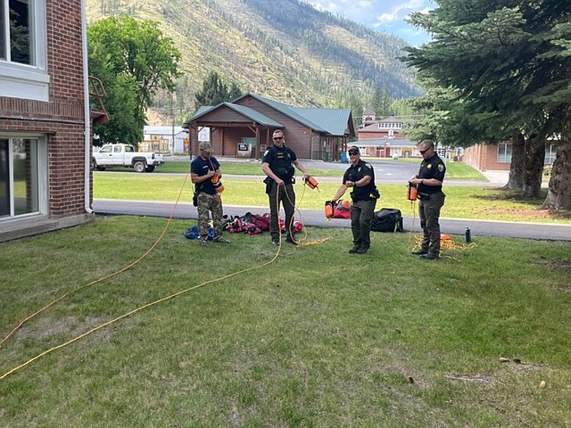 Captain Scott Dodd with the Superior Volunteer Fire Department, far left, recently instructed Mineral County deputies Eric Lindauer, Ethan Atkin and David Kunzelman on the proper way to deploy rescue bags to victims struggling in the water. Each deputy now has a rescue bag in their patrol unit. (Photo Ryan Funke)