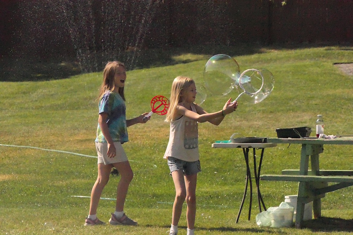 Kids cool off from the summer sun during the Saturday Farmers Market in Hot Springs. (Chuck Bandel/VP-MI)