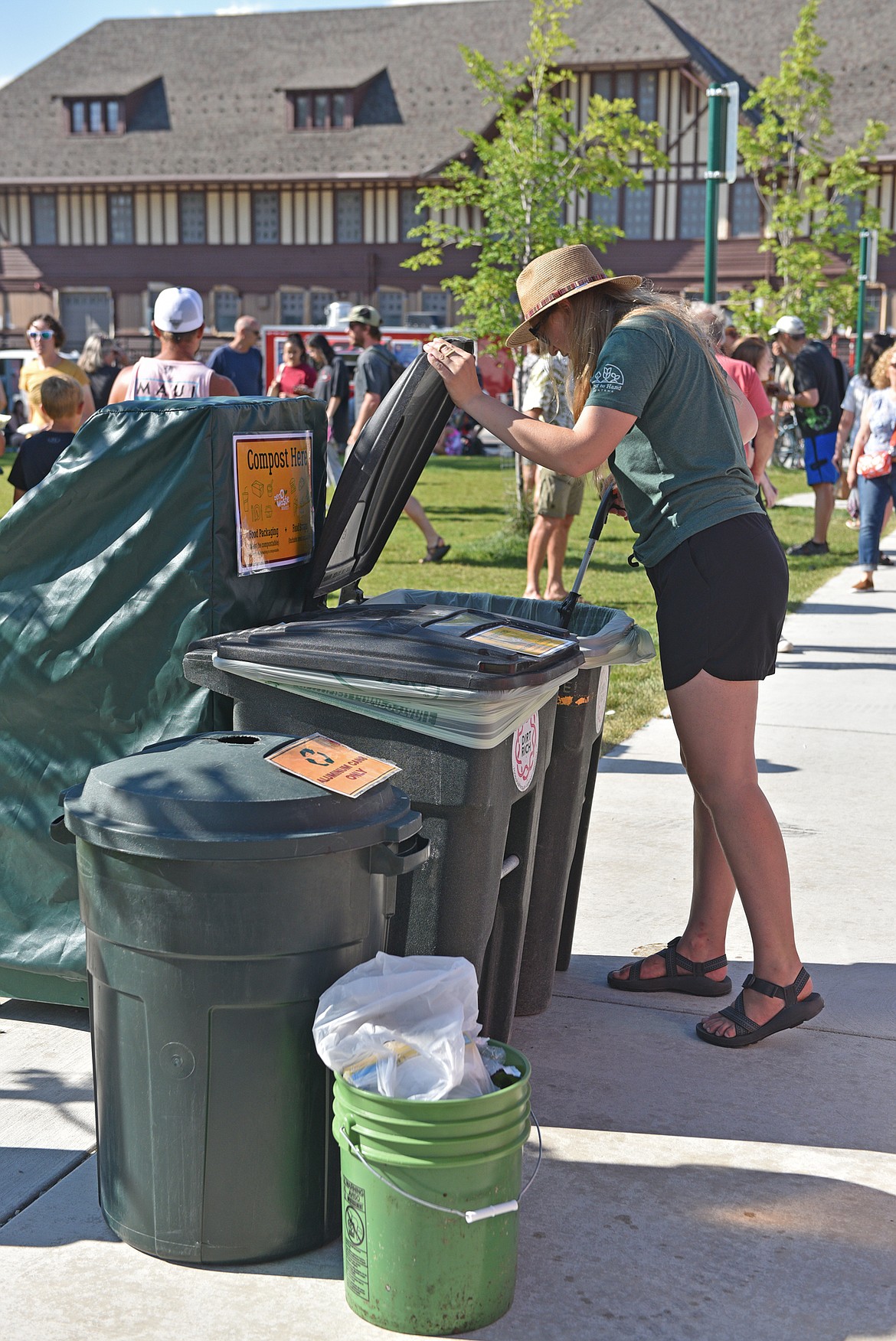 Andrea Getts with Land to Hand Montana frequently checks the bins for non-compostable materials during the Whitefish Farmers Market. (Julie Engler/Whitefish Pilot)