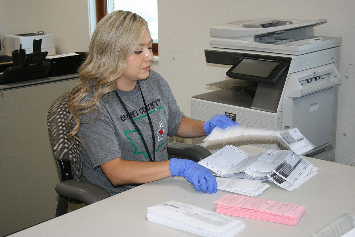 Aleanah Lopez of the Grant County Auditor’s Office begins the work of opening ballots for tabulation Tuesday afternoon. Ballots will continue to be processed as they are received in the mail.