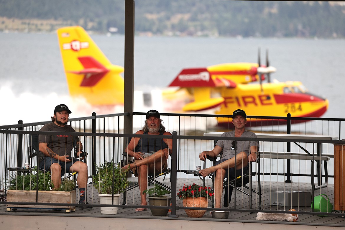 Steven Gibson, Jim Gibson and Tyler Morningstar watch the firefighting efforts combating the Elmo Fire from their home in the Chief Cliff area Monday afternoon, Aug. 1. (Jeremy Weber/Daily Inter Lake)