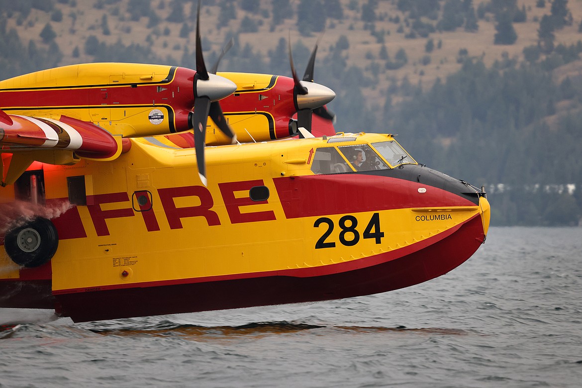 A Bridger Aerospace CL-415EAF super scooper pulls water out of Flathead Lake to fight the Elmo Fire near Chief Cliff Monday afternoon, Aug. 1. (Jeremy Weber/Daily Inter Lake)