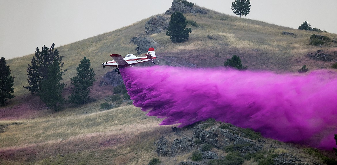 A Taylor Aviation AT-802A Air Tractor dumps fire retardant to combat the Elmo Fire near Chief Cliff Monday afternoon, Aug. 1. (Jeremy Weber/Daily Inter Lake)