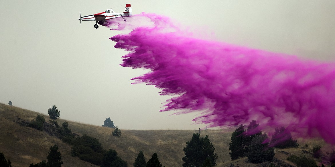 A Taylor Aviation AT-802A Air Tractor dumps fire retardant to combat the Elmo Fire near Chief Cliff Monday afternoon, Aug. 1. (Jeremy Weber/Daily Inter Lake)