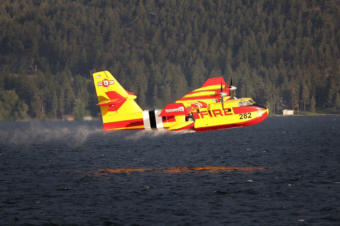 A Bridger Aerospace CL-415EAF super scooper pulls water out of Flathead Lake to fight the Elmo Fire near Chief Cliff Monday afternoon, Aug. 1. (Jeremy Weber/Daily Inter Lake)