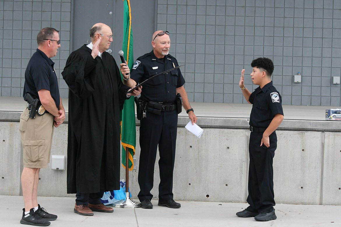 Judge John Knodell (second from left) swears in Chief for a Day Christopher James (right) Monday, assisted by Quincy Police Chief Keith Siebert (third from left) and QPD Sergeant Ryan Green (left).