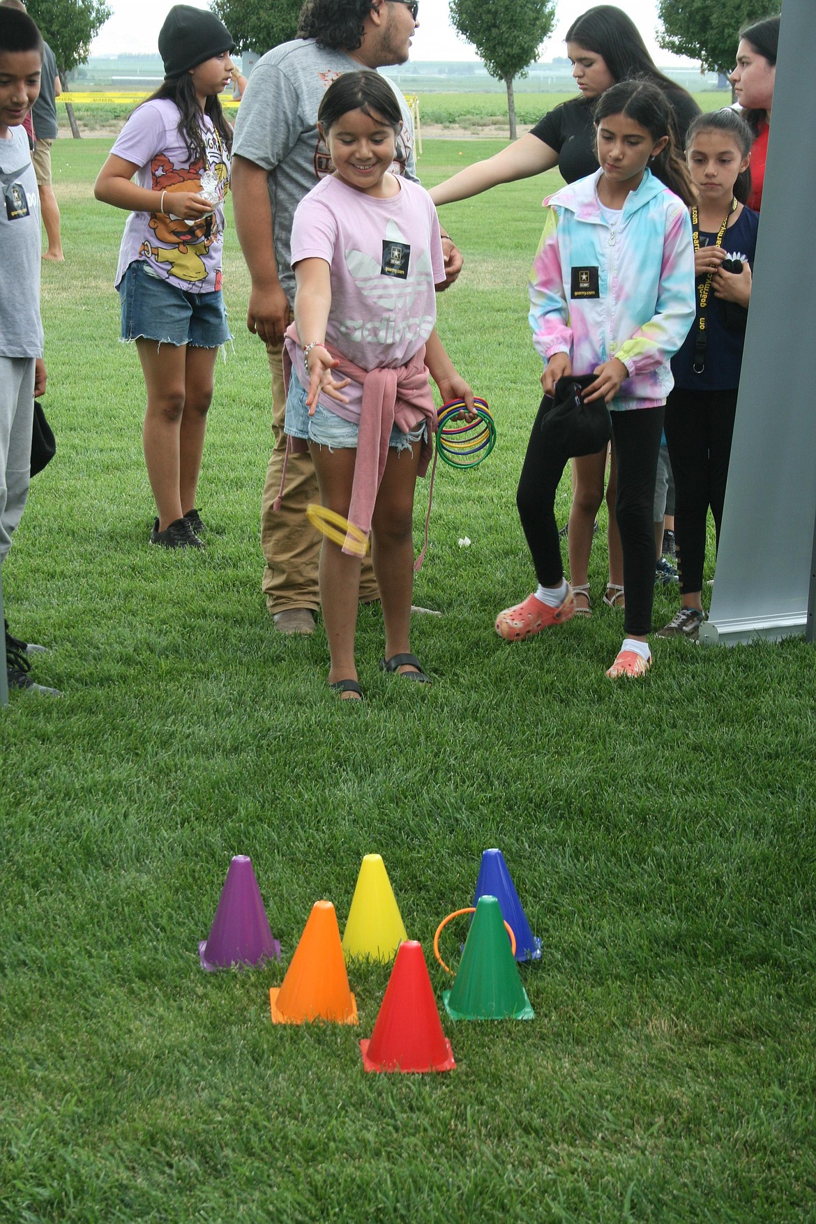 Sophie Santacruz (pink shirt) tries the ring toss game at National Night Out in Quincy.