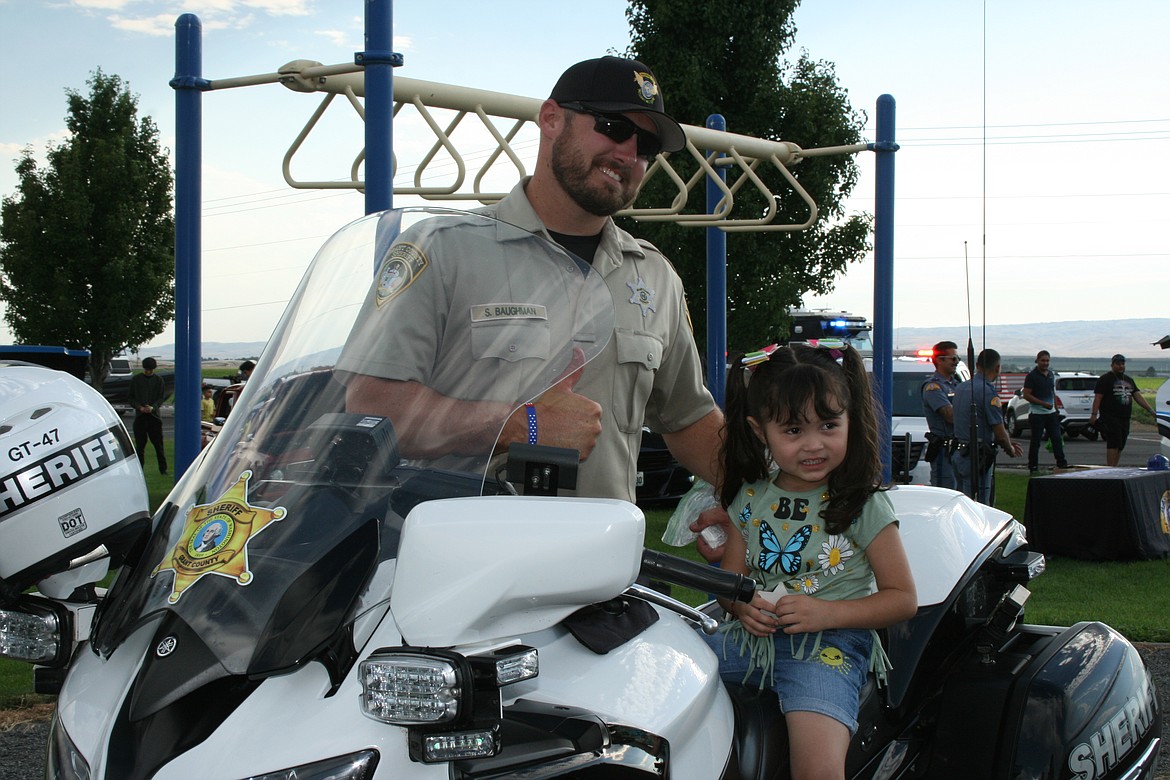 Adeline Diaz (right) gets a picture with Grant County Sheriff’s Deputy Stormy Baughman at National Night Out Monday in Quincy.