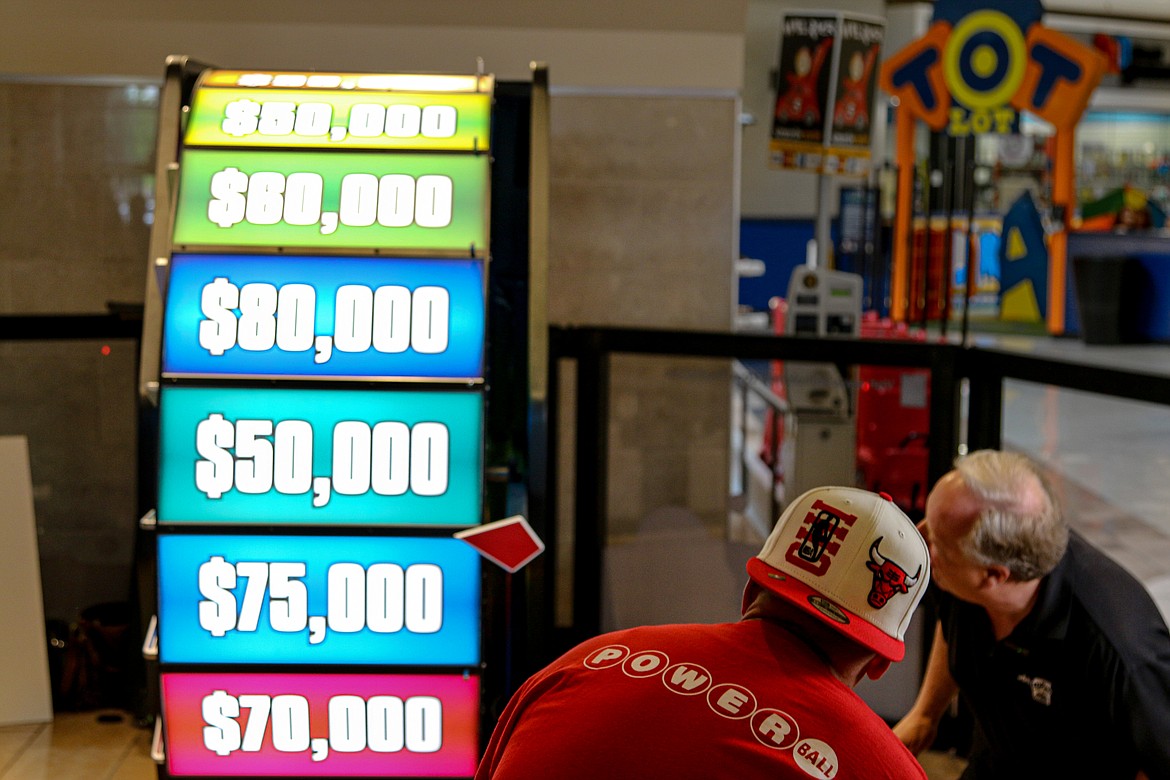 Lonnie Dahl, left, and David Workman of the Idaho Lottery watch as the Big Wheel slows to determine how much money he will win.