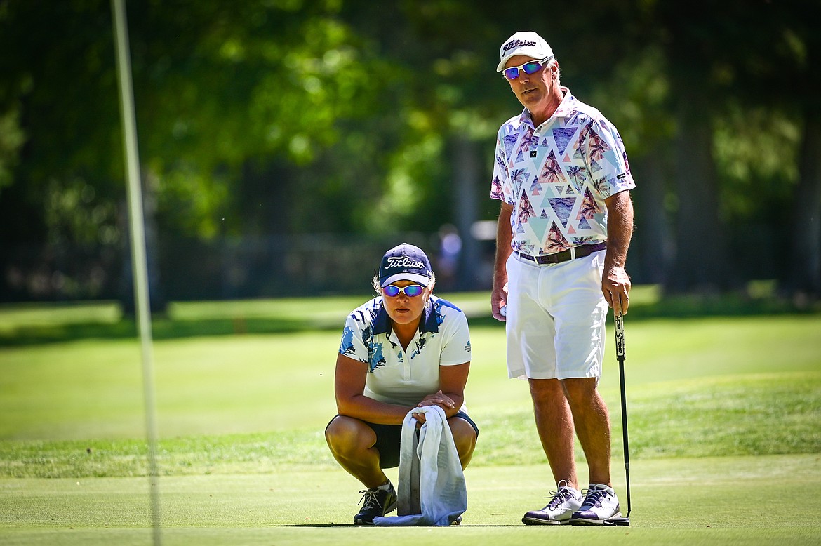 Brad Grattan and his fiance and caddie Cheryl Walter talk over a long birdie putt that Grattan would later sink on the 14th green during the Montana State Senior Golf Tournament at Buffalo Hill Golf Club on Thursday, Aug. 4. (Casey Kreider/Daily Inter Lake)