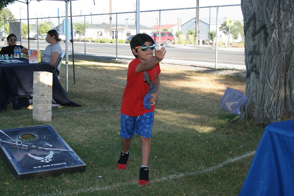 Jose Marroquin plays a beanbag toss game during National Night Out in Mattawa Aug. 2.