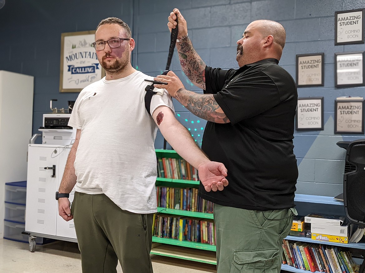 Silverback instructor Seth Mason demonstrates how to correctly place a tourniquet on the arm of a crisis actor.