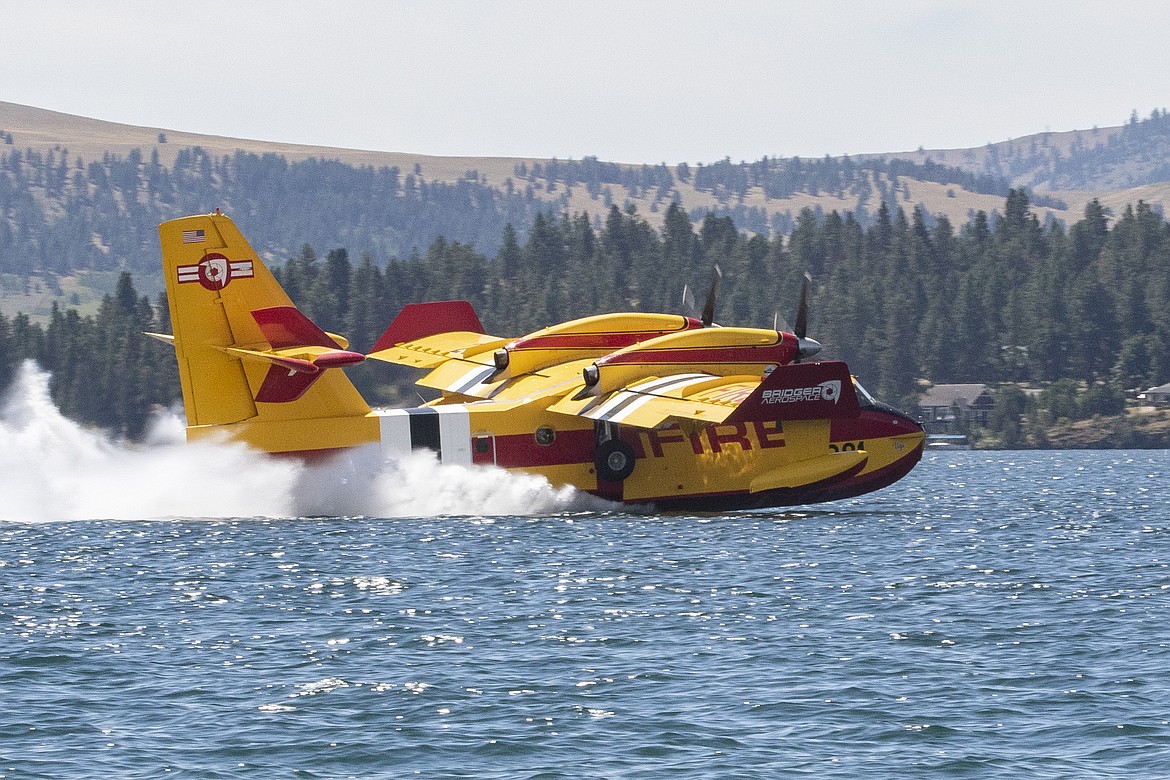 A scooper plane assigned to the Elmo 2 Fire dips into Flathead Lake. (Rob Zolman/Lake County Leader)