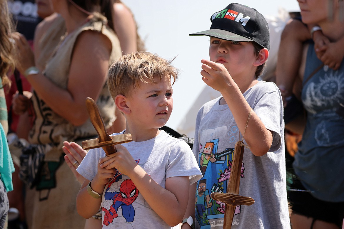 A pair of young spectators take in the medieval combat demonstration at the Montana Renaissance Faire on the grounds of the Majestic Valley Arena Saturday, July 30. (Jeremy Weber/Daily Inter Lake)