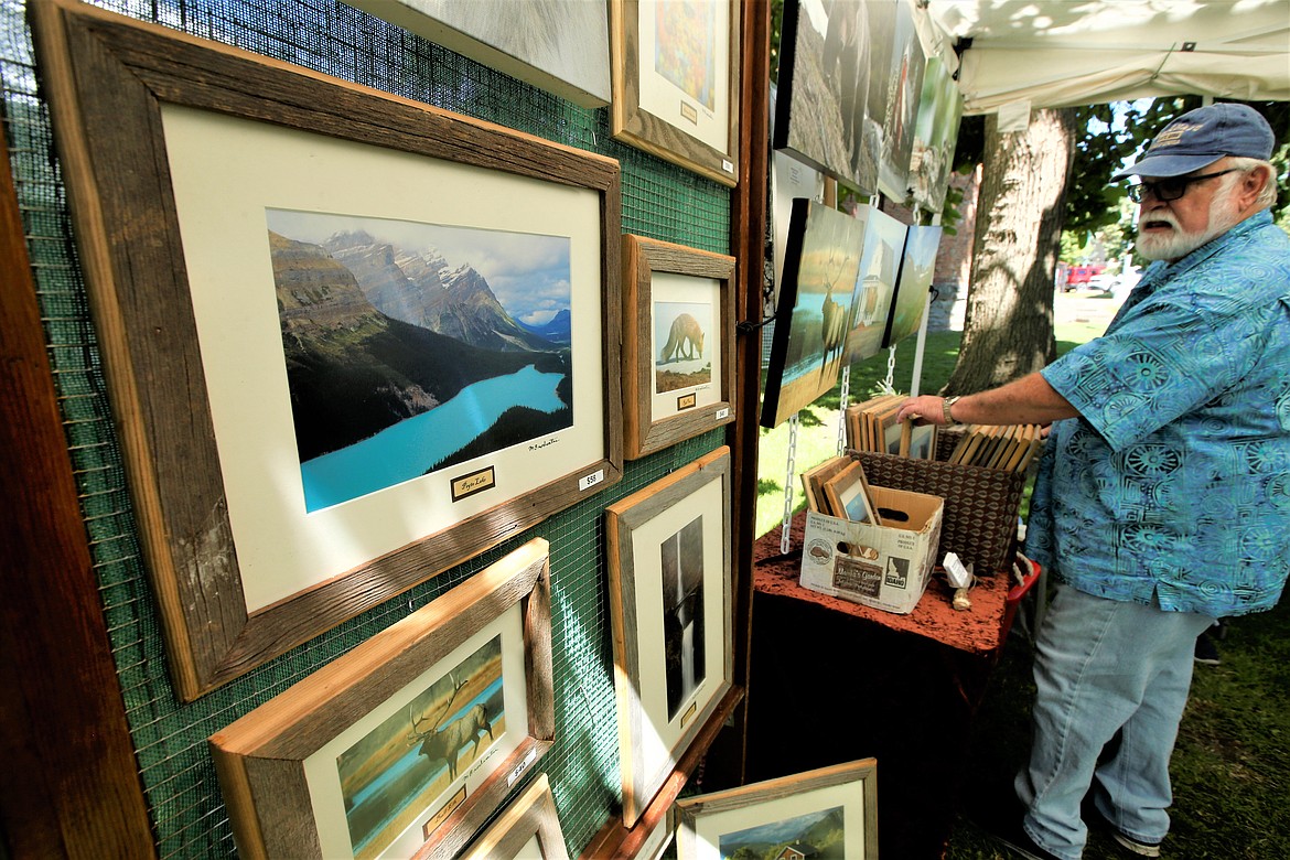 Glenn Fry looks over the photography of Mike Brodwater at Taste of Coeur d'Alene on Friday.