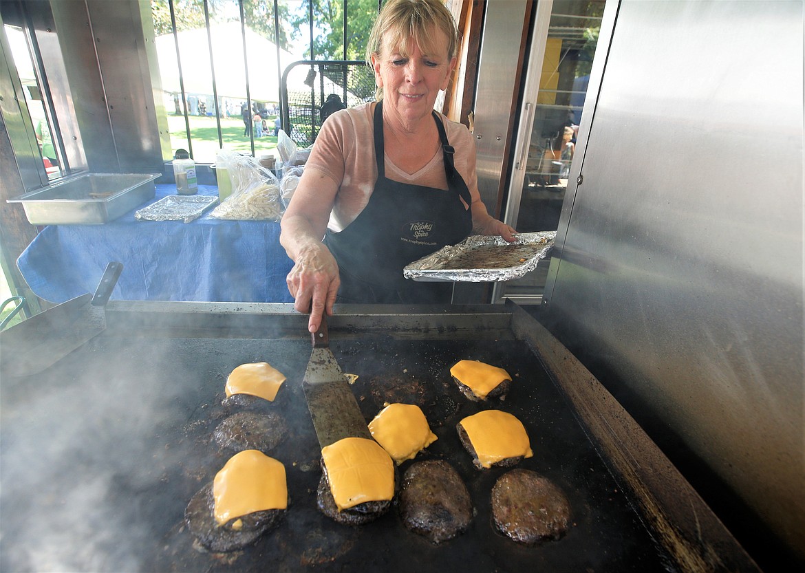 Karen Botai cooks up Trophy Elk Burgers on Friday at Taste of Coeur d’Alene at City Park.