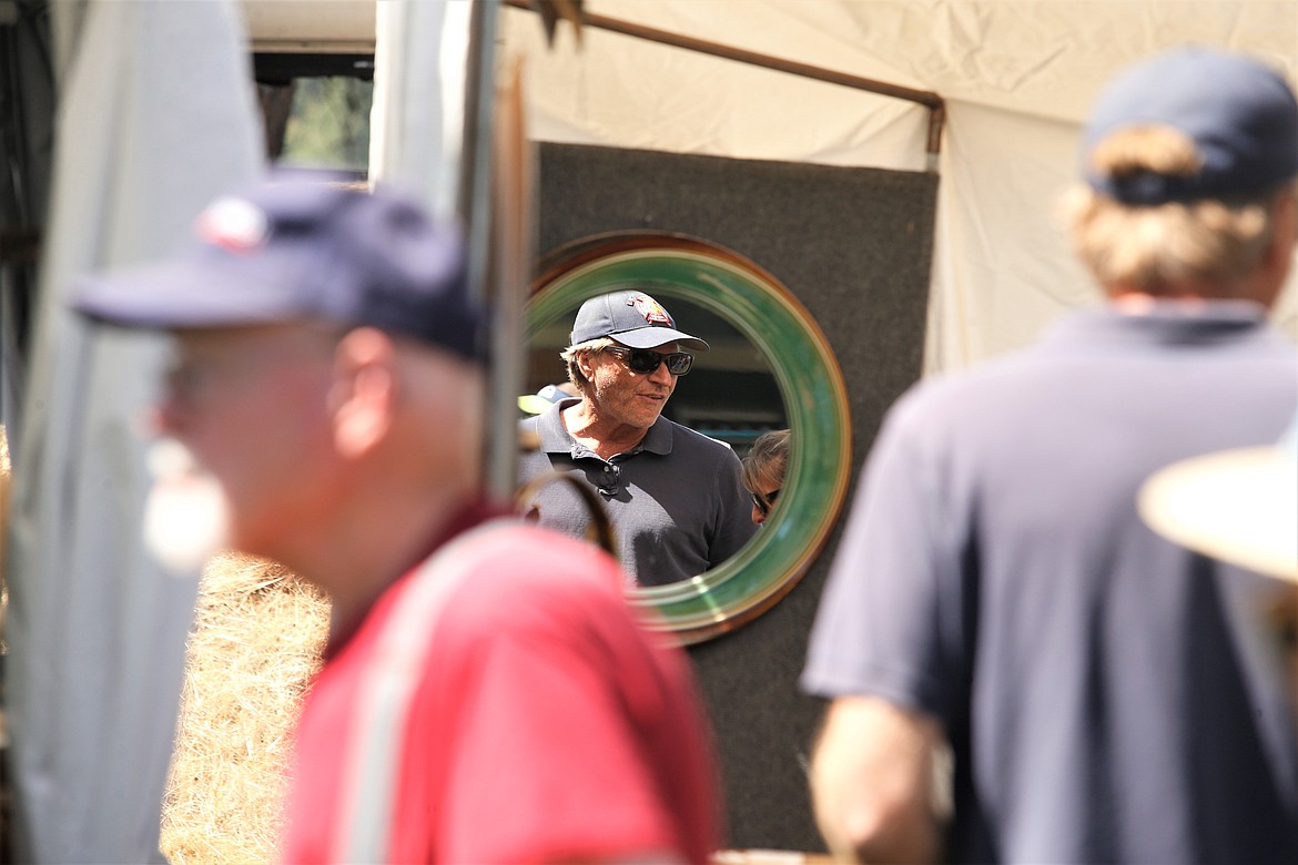 A man is reflected in a mirror at Art on the Green on Friday.