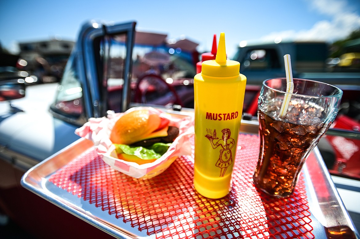 A drive-in tray with a decorative cheeseburger, condiments and soda hang from the window of a 1959 Ford Galaxie at the Evergreen Show 'N Shine car show at Conlin's Furniture on Saturday, Aug. 6. (Casey Kreider/Daily Inter Lake)