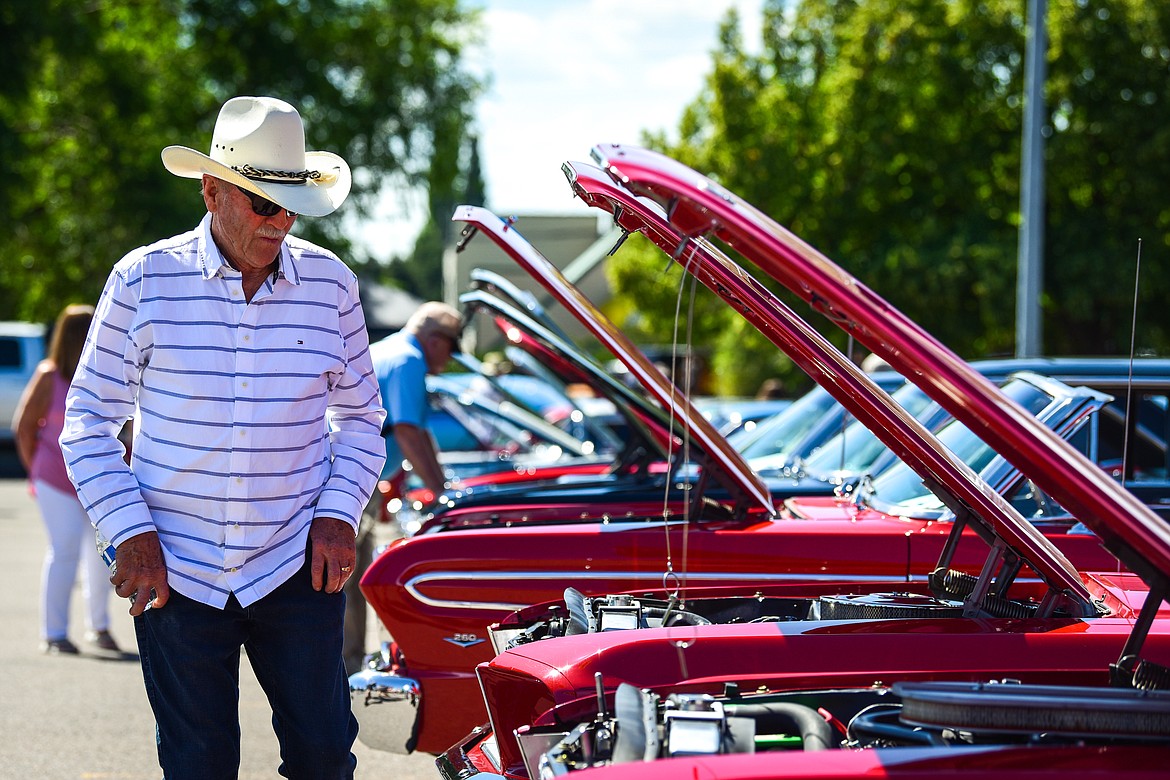 Gerry Collom checks out a row of Ford Mustangs at the Evergreen Show 'N Shine car show at Conlin's Furniture on Saturday, Aug. 6. (Casey Kreider/Daily Inter Lake)