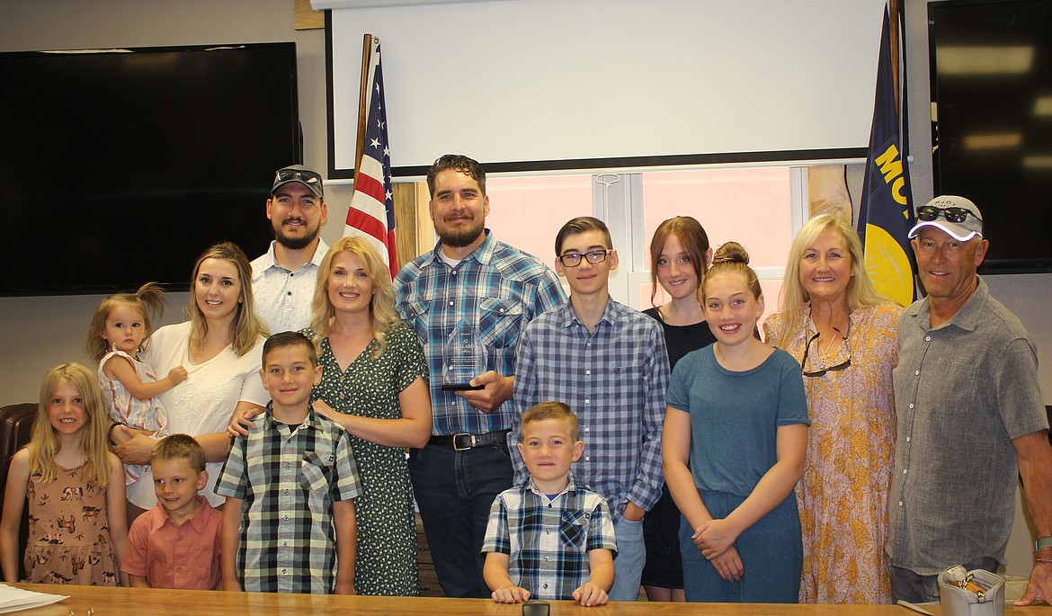 AJ Allard, center, is surrounded by his family during a ceremony that was held in his honor at the Mineral County Commissioners Conference Room last week. Allard, all alone, ran into a burning house near superior and rescued 2 people that would have perished. (Monte Turner/Mineral Independent)