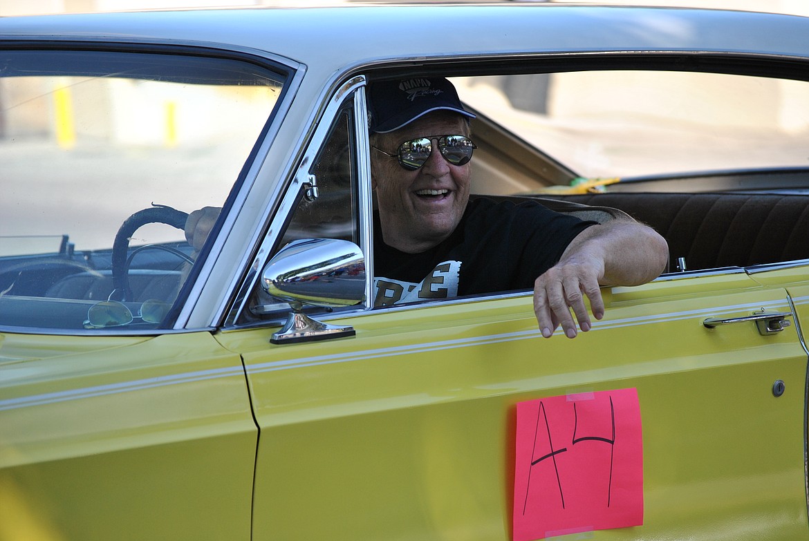In his big yellow, Chrysler Newport, Gordon Hendrick cruises down River Street during Saturdays parade. (Mineral Independent/Amy Quinlivan)
