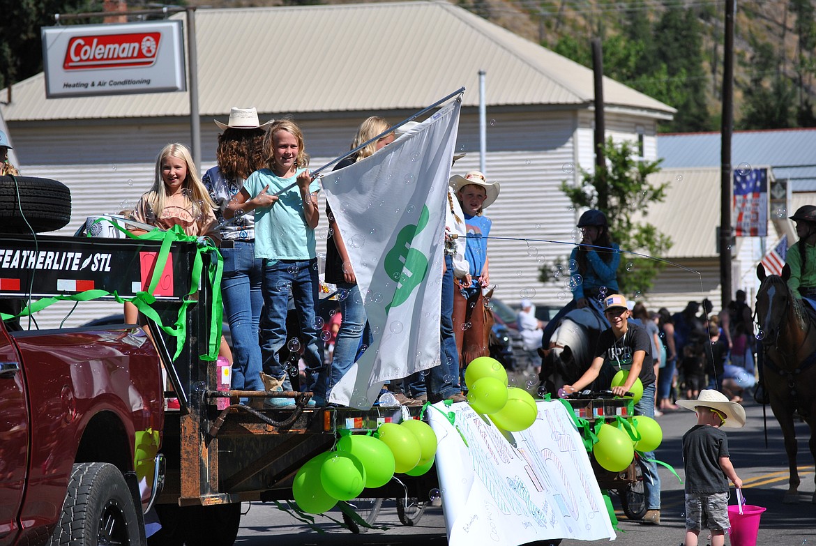 Ayla waves the 4-H flag aboard a float in the Mineral County Fair parade. (Mineral Independent/Amy Quinlivan)