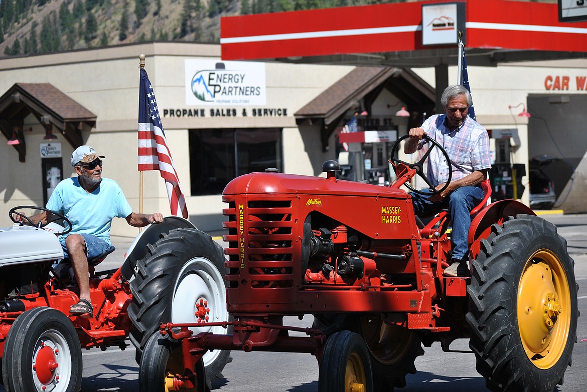 Left, Garry Garber, and right, Bobby Clyde maneuver their vintage tractors in the Mineral County Fair Parade.  (Mineral Independent/Amy Quinlivan)