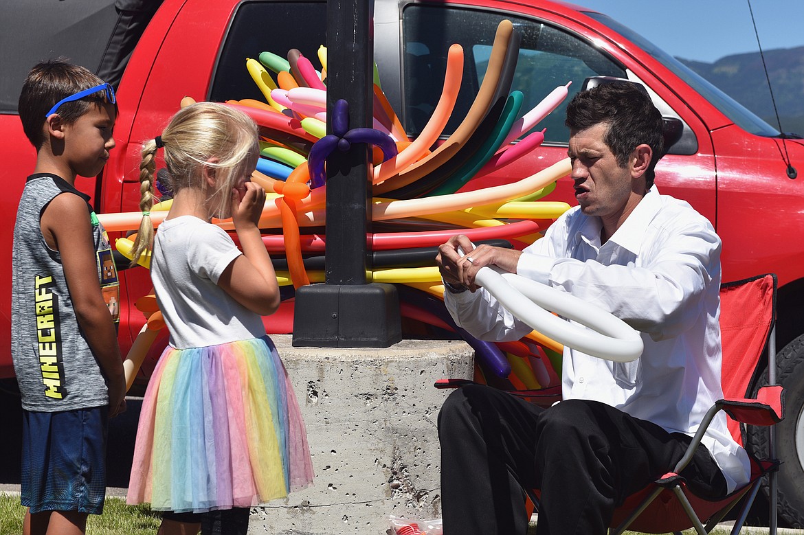 Drew Miller, a magician and balloon artist, makes a white butterfly, as requested, at the Kids Fair. (Julie Engler/Whitefish Pilot)