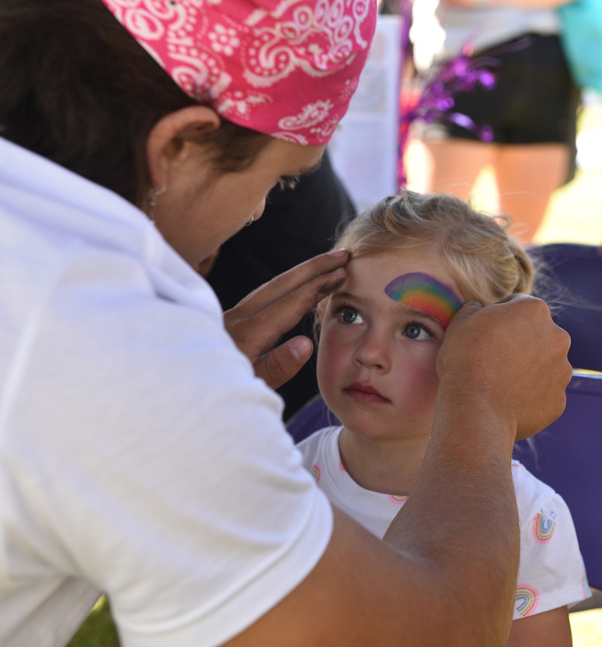 Devin Beale provided face painting at the Stumptown Art Studio booth during the Kids Fair on Aug. 3 at Logan Health Whitefish. (Julie Engler/Whitefish Pilot)