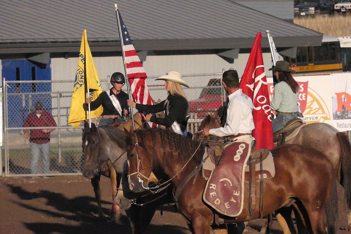 Flags, horses and riders assemble in the middle of the Mineral County Fairgrounds arena Saturday prior to the start of the second day of the Lions Club Rodeo. (Chuck Bandel/MI-VP)