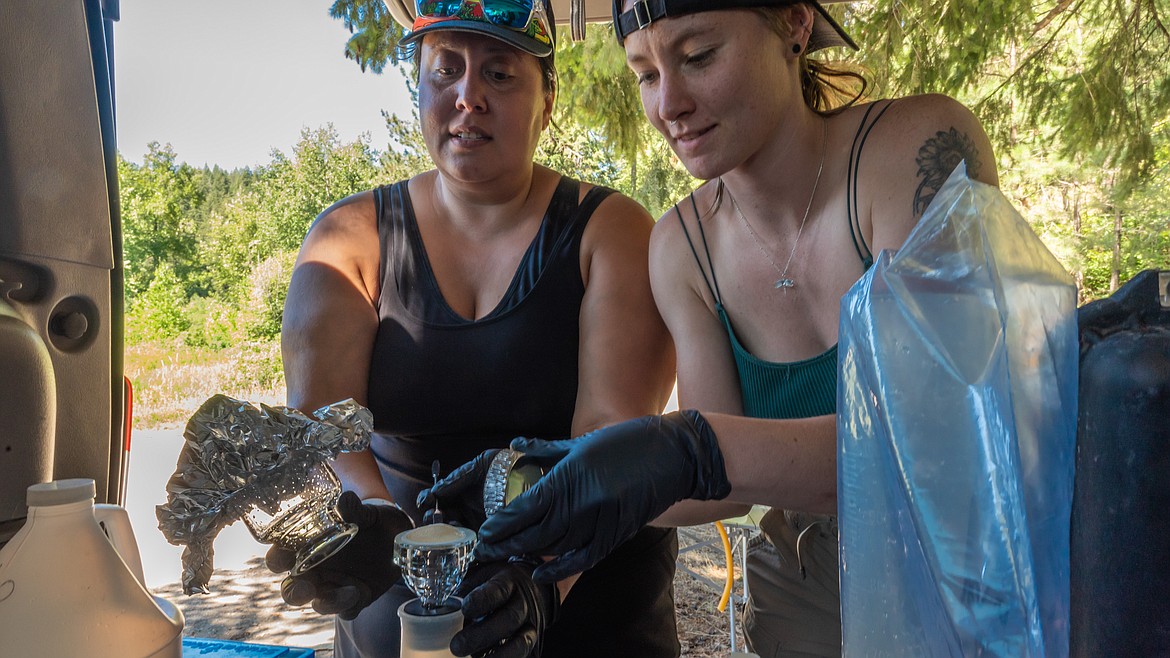 Krystal Saunoa, an INBRE fellow from the University of Idaho, left, and Eryn Pierce, a North Idaho College student and INBRE intern, filter water samples in the field for Pierce’s water quality project in Loffs Bay on Lake Coeur d’Alene in July.