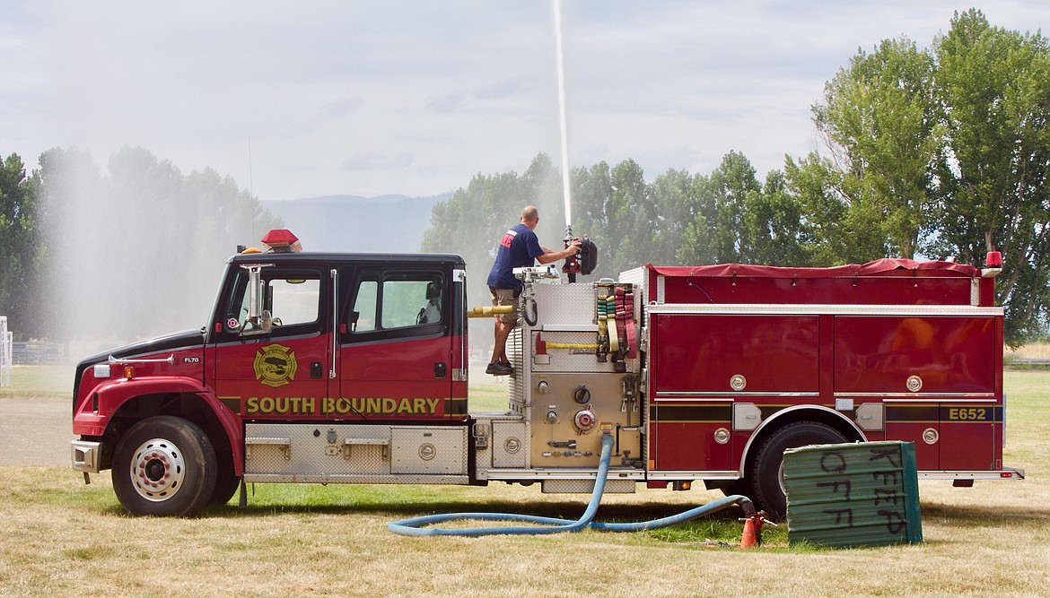 Chief Tony Rohrwasser of South Boundary Fire District hoses down hot fair goers.