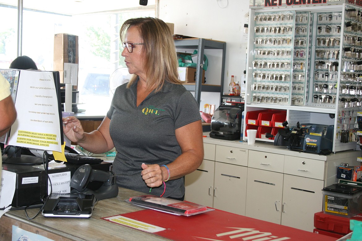 Quincy Hardware and Lumber owner Tina Stetner helps a customer at the counter.