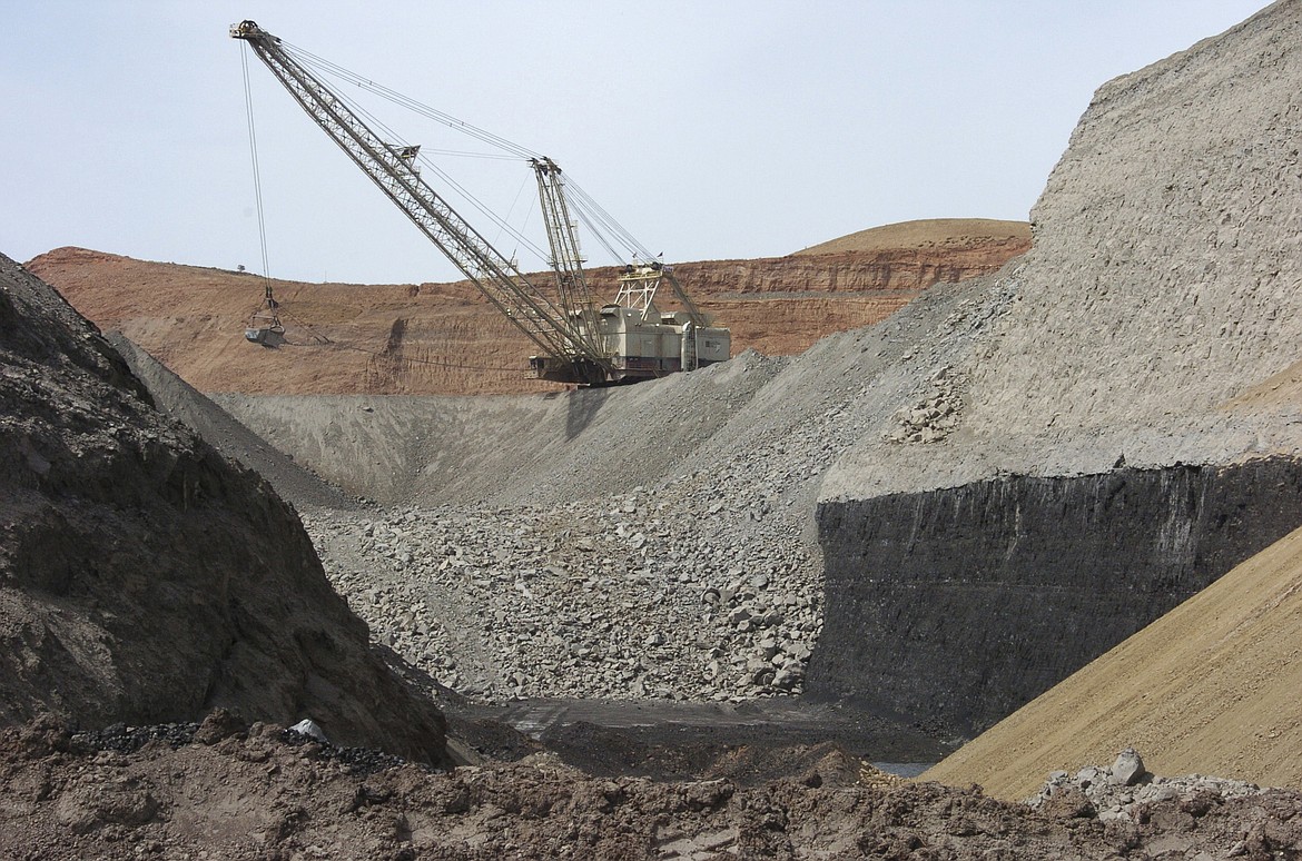 FILE - In this April 4, 2013, file photo, a dragline excavator moves rocks above a coal seam at the Spring Creek Mine in Decker, Mont. A federal judge has reinstated a moratorium on coal leasing from federal lands that was imposed under former President Barack Obama and then scuttled under former President Donald Trump, Friday, Aug. 12, 2022. (AP Photo/Matthew Brown, File)