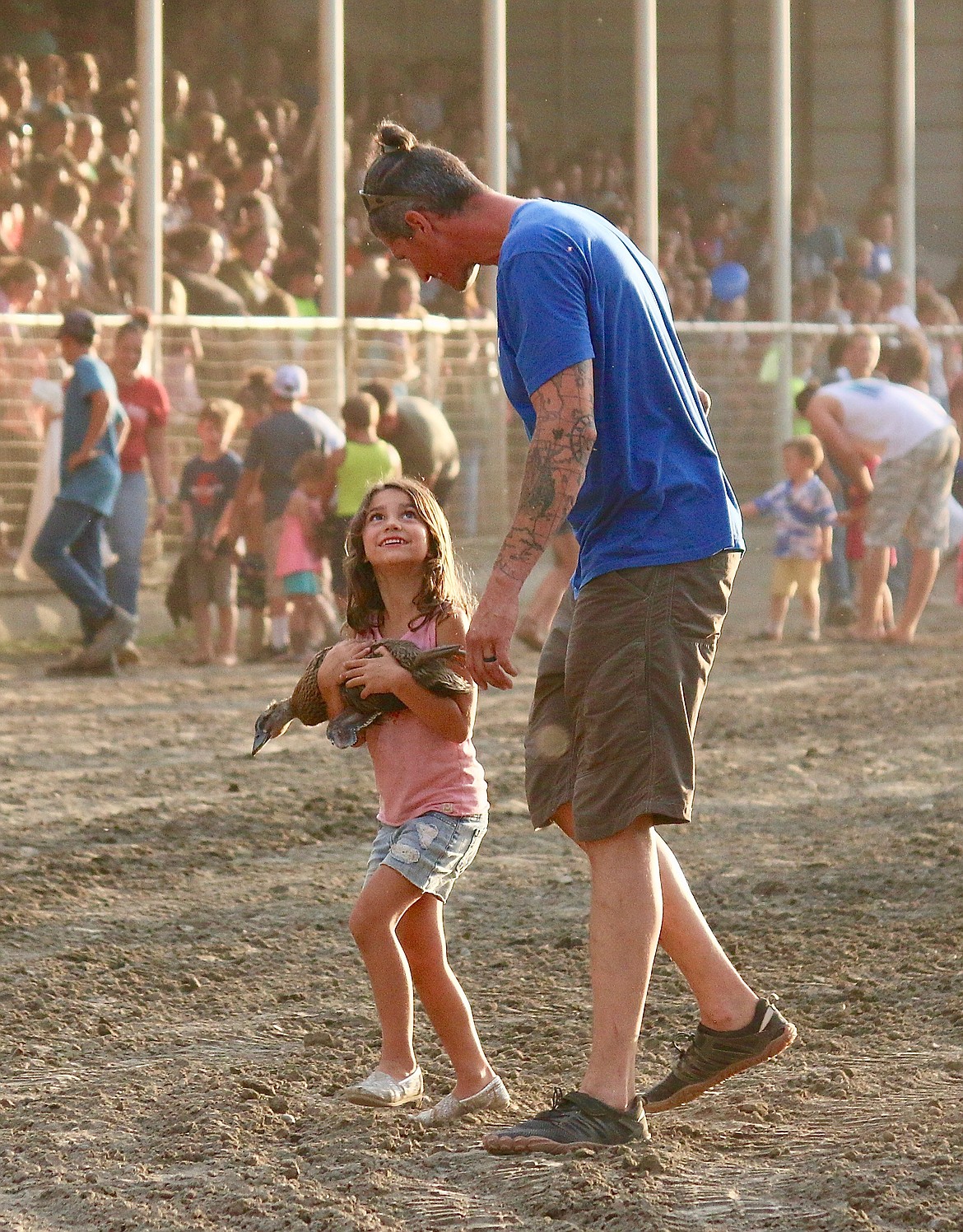 Father and daughter walk with prize after catching a duke during Family Fun Night.