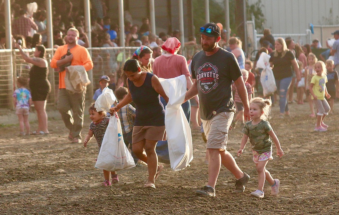 Parents help kids carry prize after chicken and duck chase at Family Fun Night during the 102nd Boundary County Fair.