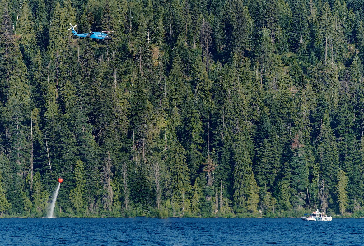 A helicopter scoops a bucket of water on Aug. 8 to help fire the Lions Roar Fire. James Fillmore said crews used a fleet of four AT802 Conair "Fire Boss" planes plus three different types of helicopters, including a Blackhawk. A couple of fire boats cleared pleasure boats out of the flights paths before operations started.