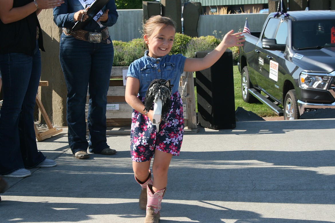 Charleigh Brumet waves to the crowd during the grand entry at the Pee Wee Stampede.