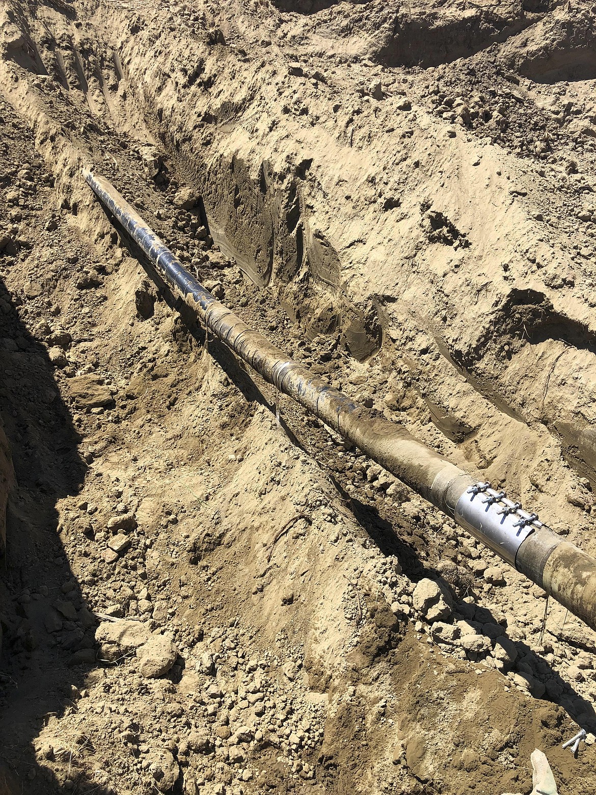 This undated photo provided by Bridge Pipeline shows repairs made to a six-inch pipeline transporting diesel that broke and spilled more than 45,000 gallons of fuel on July 27, 2022. near Sussex, Wyo. The line is owned by a Wyoming company that's being sued by federal prosecutors over previous spills in two other states. (Bridge Pipeline via AP)