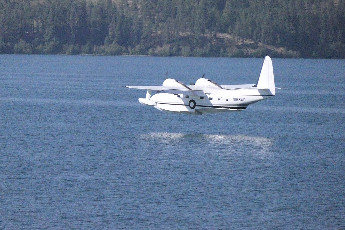 A "classic" Grumman Mallard, which was later transformed into the Albatross, prepares to touch down on the glassy surface of Lake Mary Ronan during a seaplane fly-in Saturday morning.  (Chuck Bandel/VP-MI)