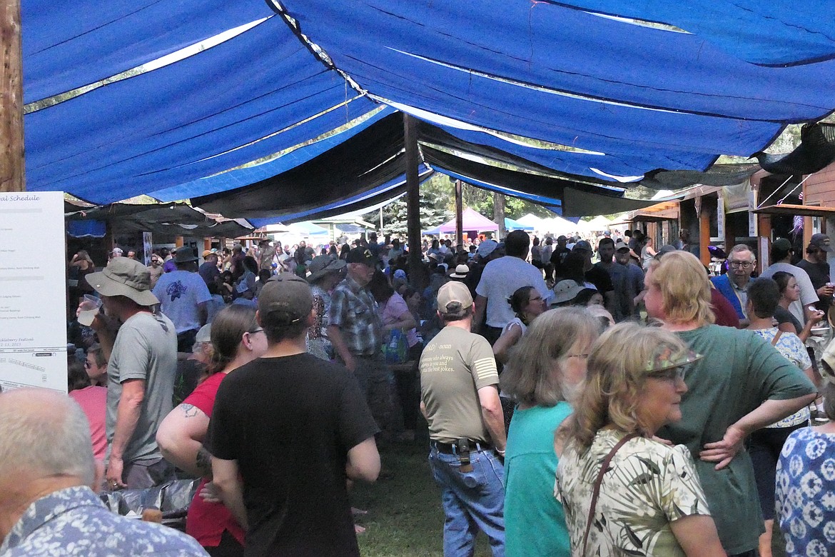 Part of the crowd under the craft and food booth tents along the Huckleberry Festival's "midway" this past Saturday in the city park at Trout Creek. (Chuck Bandel/VP-MI)