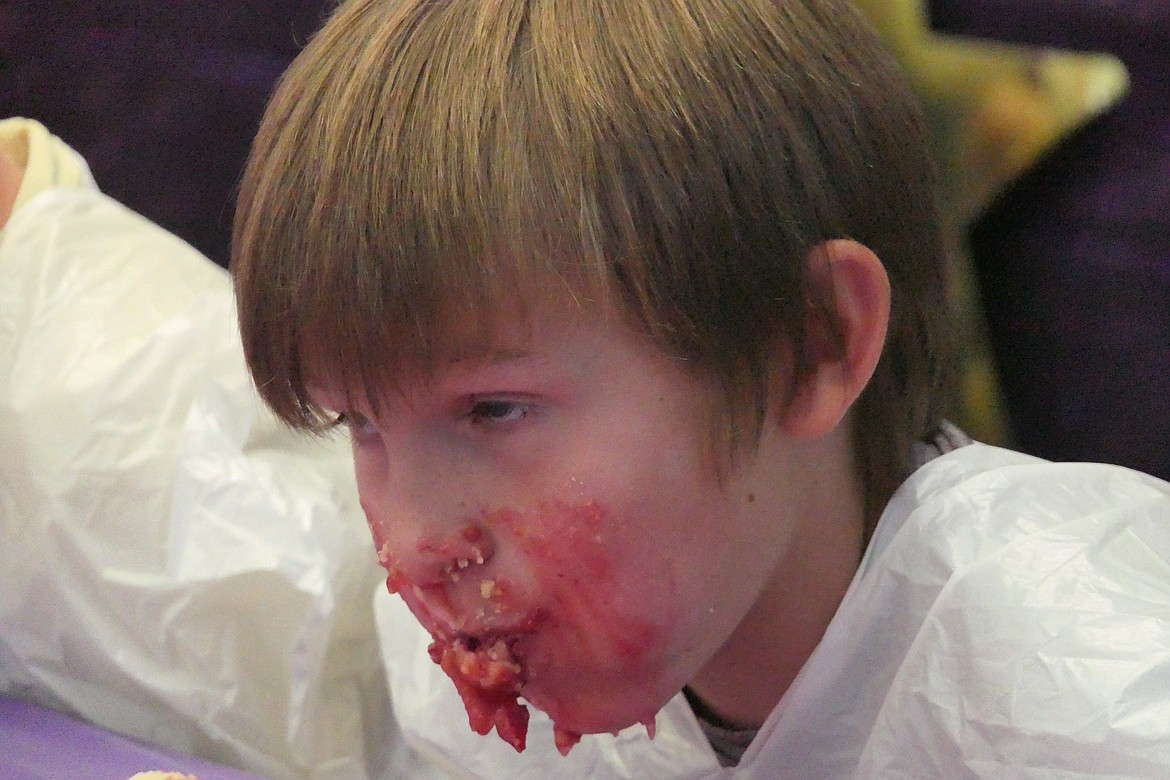 Pie eating age group winner Christian, 8, looks like he's filling up on pie during a short respite in Saturday's pie eating contest.  More than 30 pie eaters entered the contest. (Chuck Bandel/VP-MI)