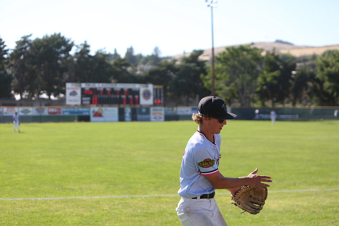 A Southeast Tropic outfielder runs towards the left field fence in an attempt to catch a foul ball.