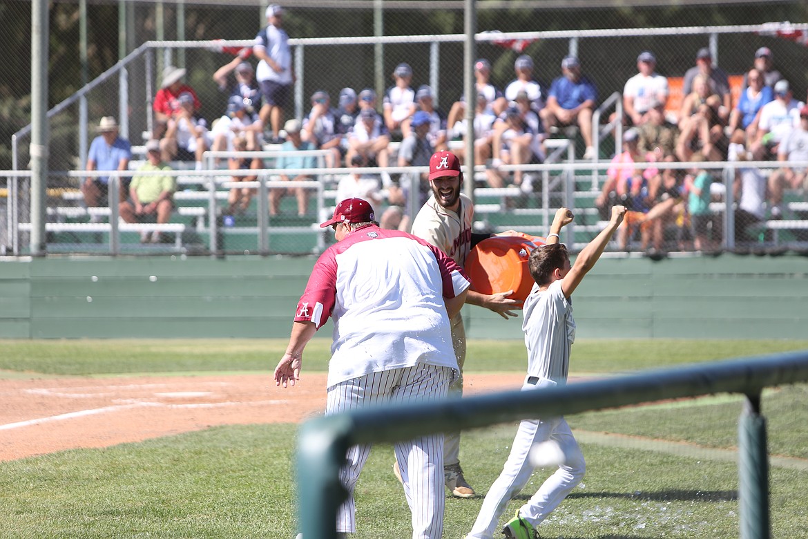 Alabama head coach Tony Hendrix received a Gatorade bath after the win, brought out by Jake Thoman and a bat boy.